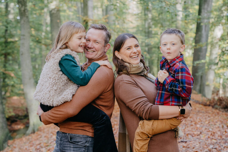 Kinder auf dem Arm ihrer Eltern und haben Spaß beim kostenlosen Fotoshooting